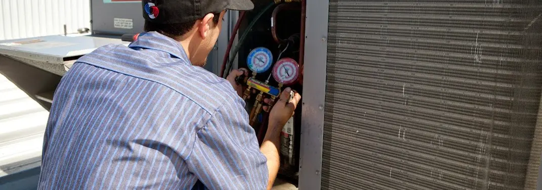 HVAC technician servicing a condenser unit in Long Grove