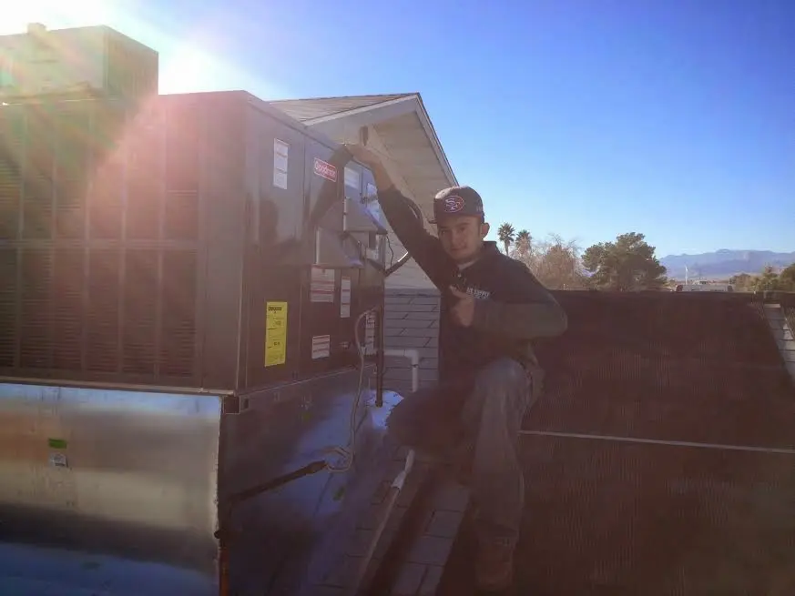 HVAC technician performing Air Duct Cleaning on a rooftop unit in Long Grove
